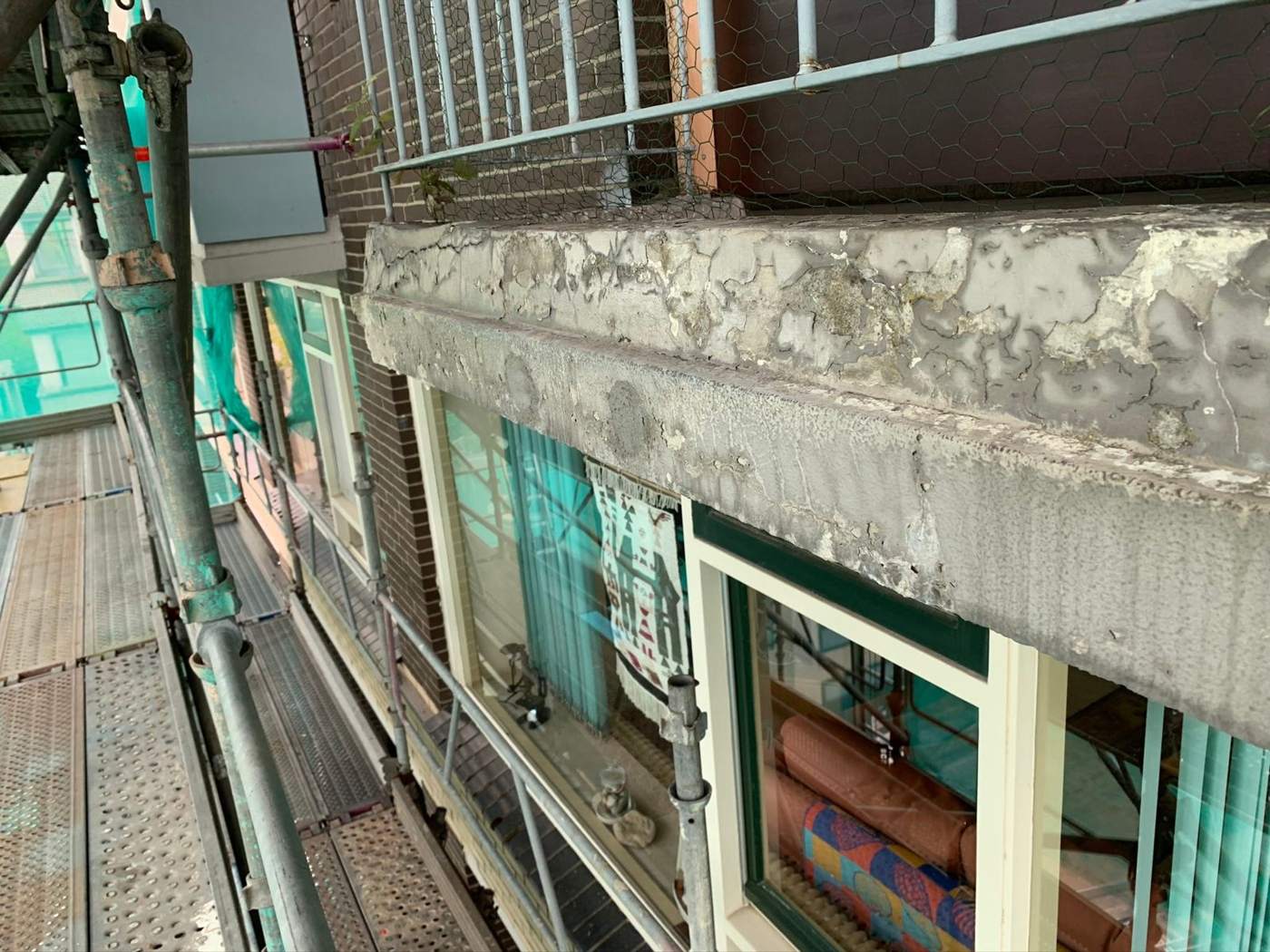 Balkon en galerij van een appartementencomplex tijdens renovatie met steiger