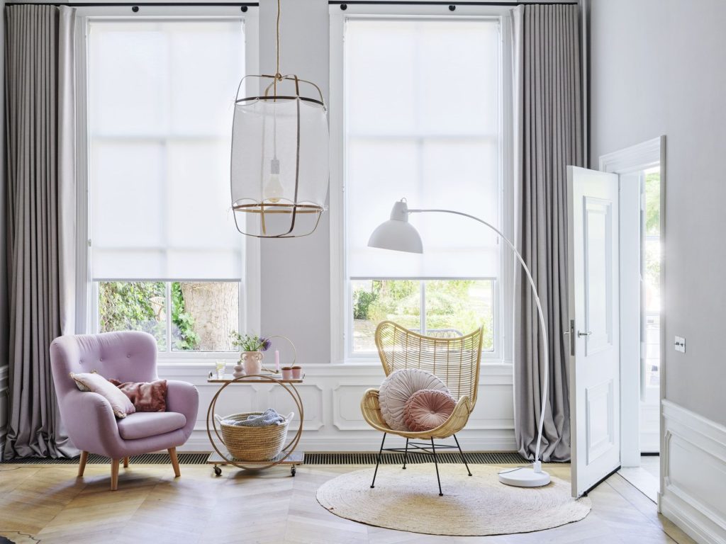 Overgordijnen en transparante rolgordijnen in een woonkamer