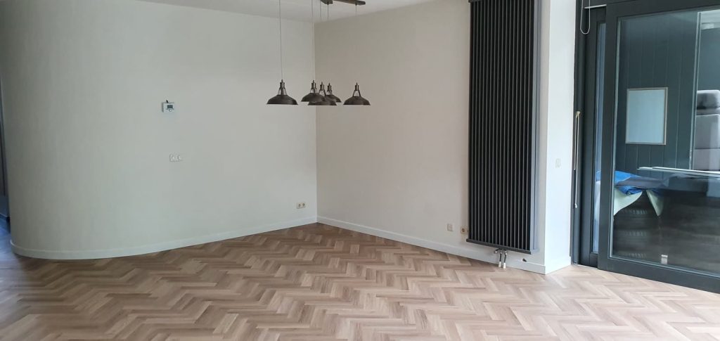 Lichte PVC visgraatvloer in eetkamer met hanglampen
