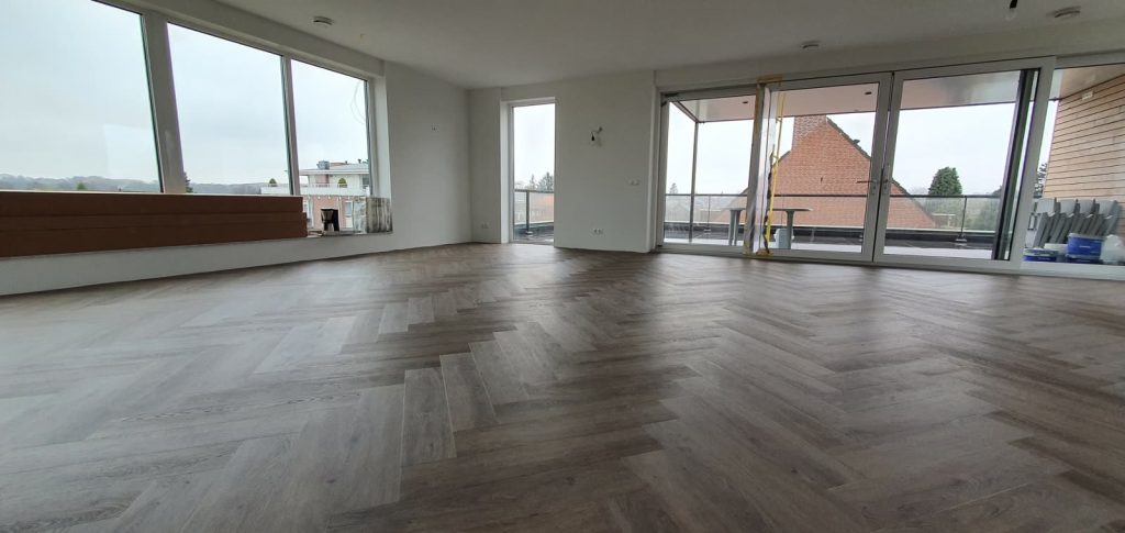 PVC visgraatvloer in ruime woonkamer met grote ramen
