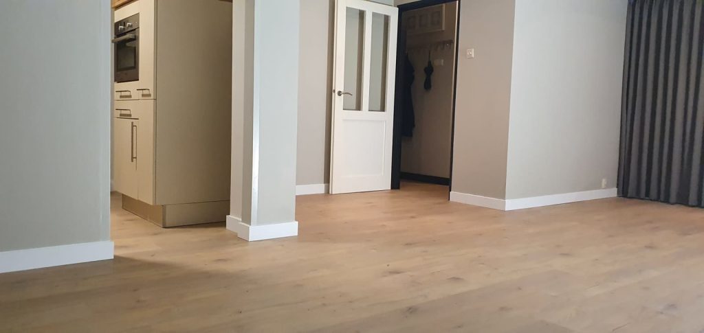 Licht eiken PVC vloer in woonkamer met taupe wanden