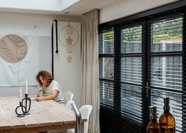 Keuken met zwarte shutters voor de grote ramen onder een lichtstraat