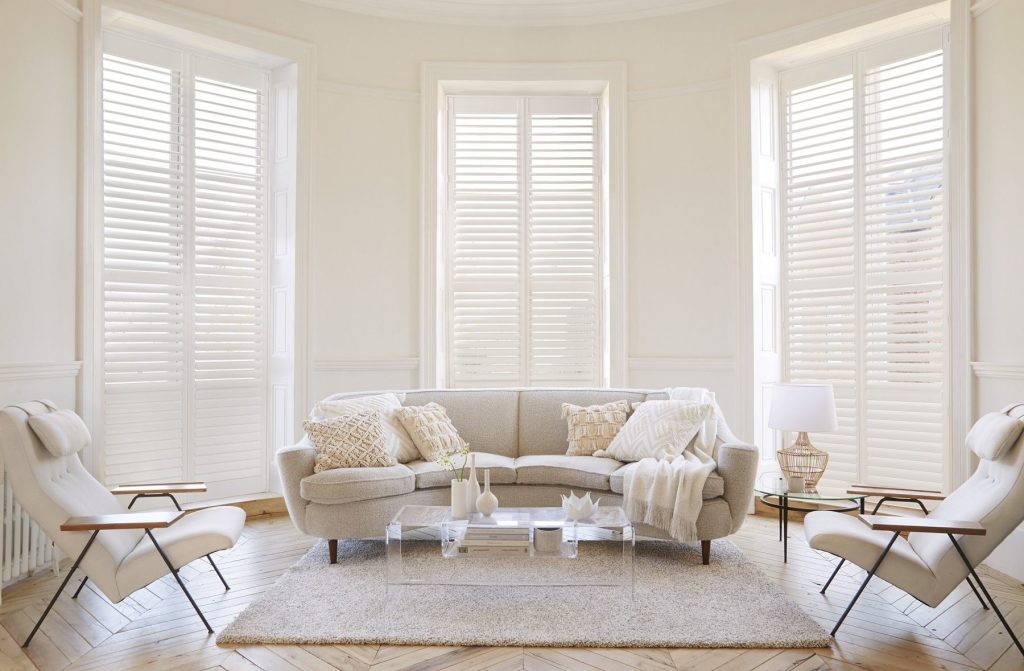 Witte shutters voor een raampartij in een woonkamer