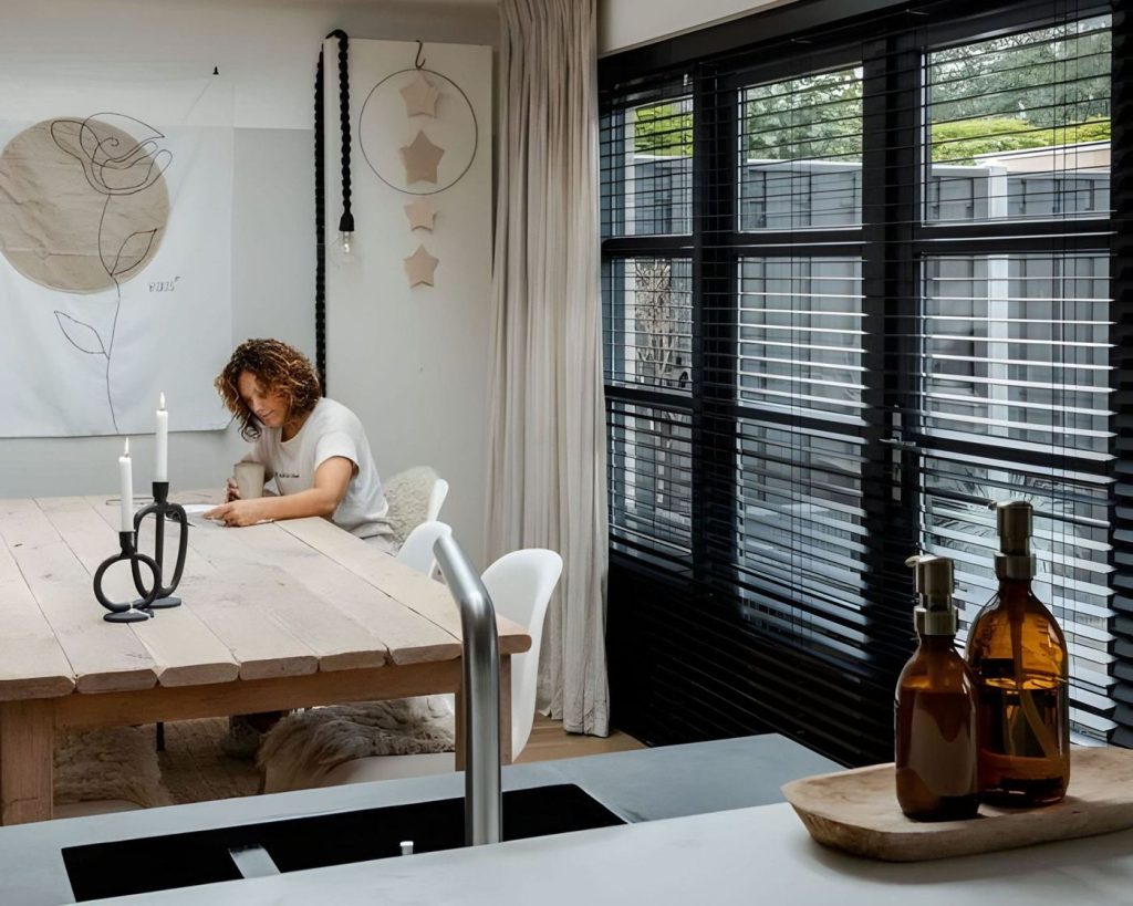 Woonkeuken met eettafel en zwarte shutters voor de tuindeuren