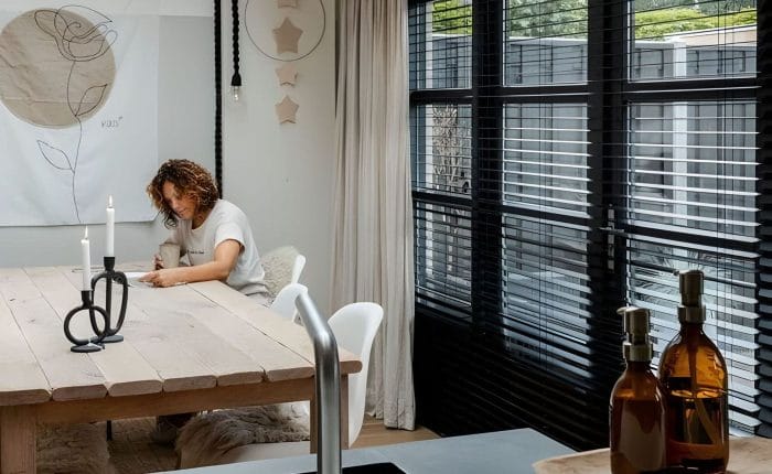 Woonkeuken met eettafel en zwarte shutters voor de tuindeuren