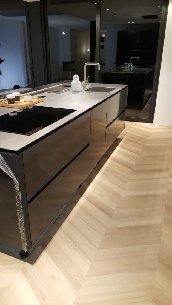 Strakke keuken met keukeneiland op een visgraatvloer in houtlook